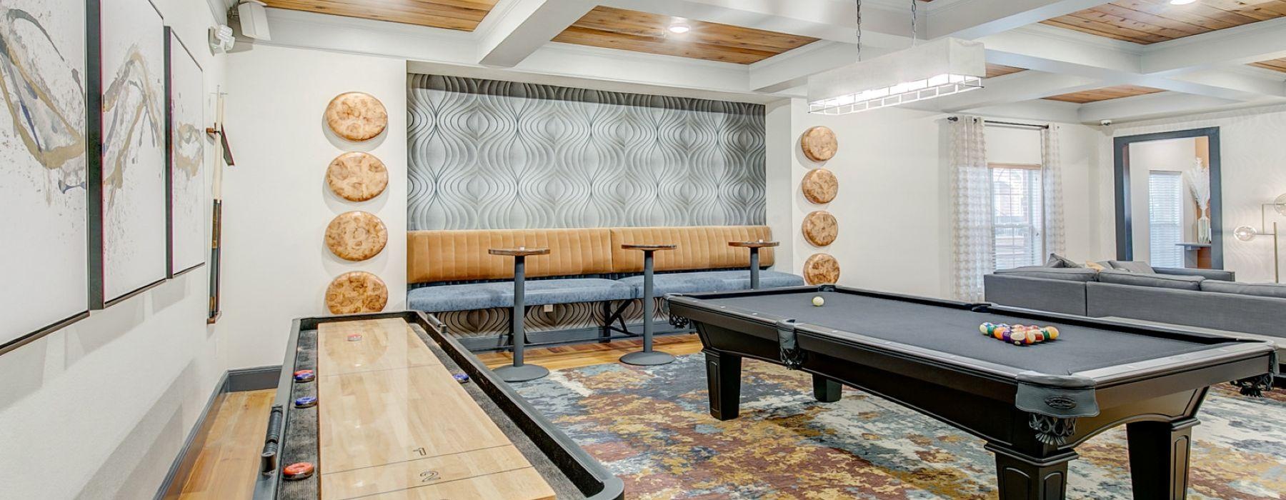 a room with a pool table and a shuffle board