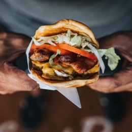 a person holding a burger